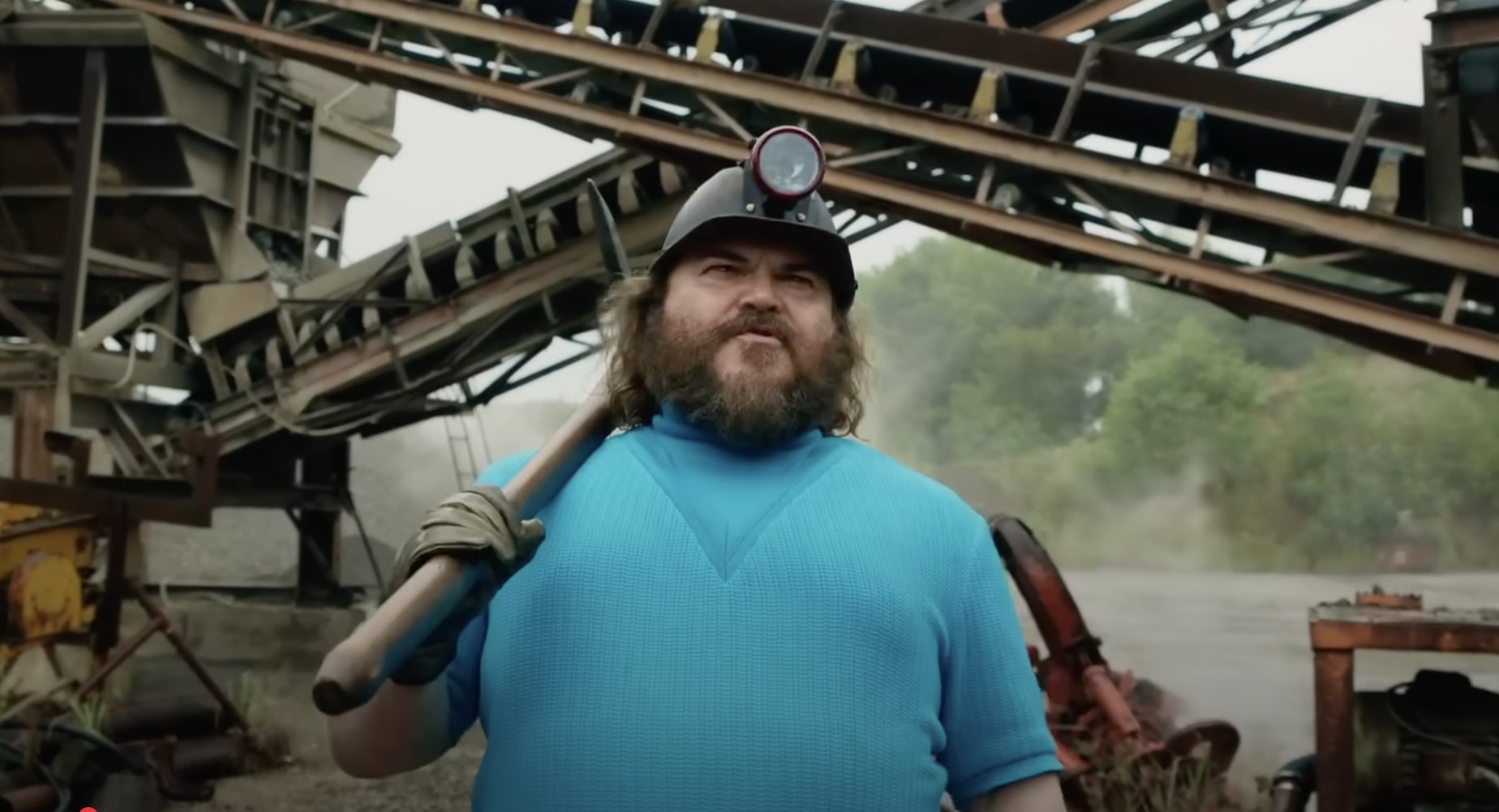 Screenshot of A Minecraft Movie, featuring Jack Black holding a pickaxe.